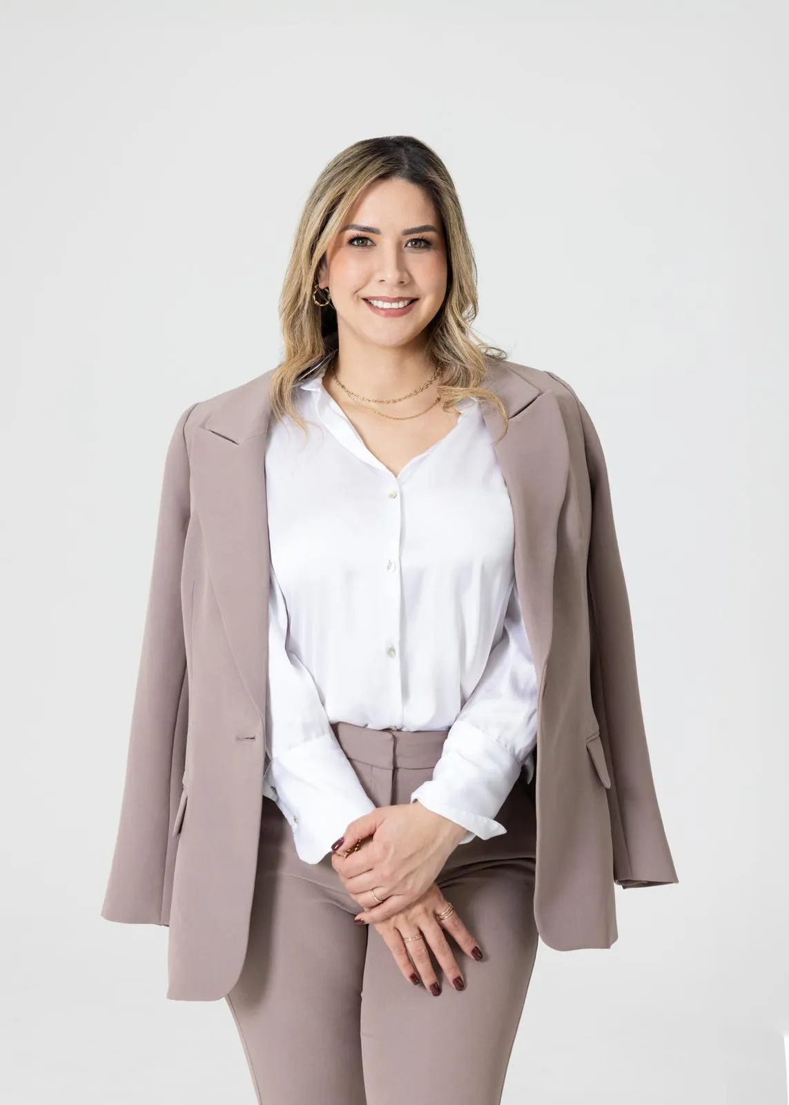 Faviola Maestre, asesora de seguros, sonriendo con traje color arena